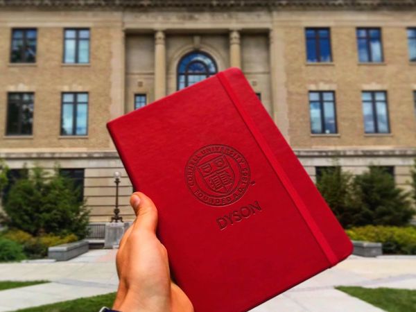 Holding a Dyson notebook next to Warren Hall