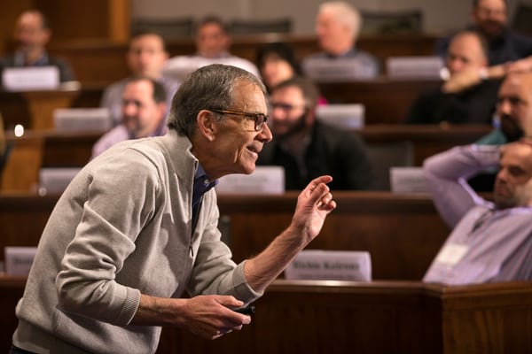 Professor Ed McLaughlin speaking to adult students with descriptive hand motions during lecture