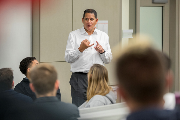 Reggie addresses students in the front of a classroom
