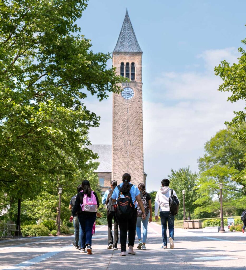 Students walking outside towards the clock tower.