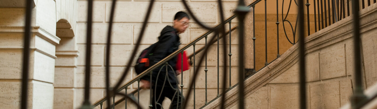 A student walks up the main entrance staircase in Warren Hall.