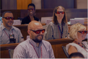 A group of participants wear glasses as they learn 