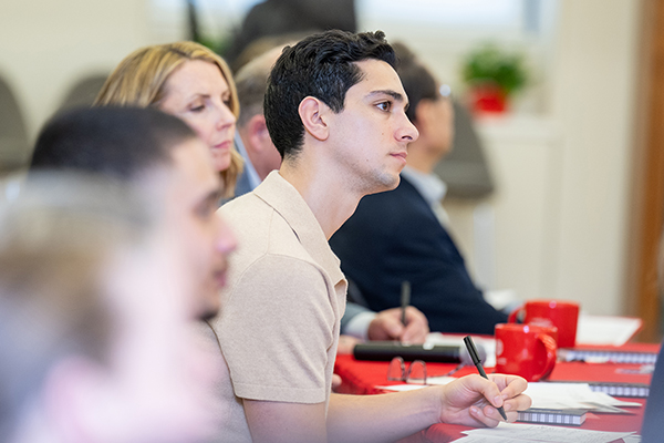 A student listening intently and taking notes.